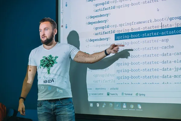 Mikalai walking through code projected on the screen